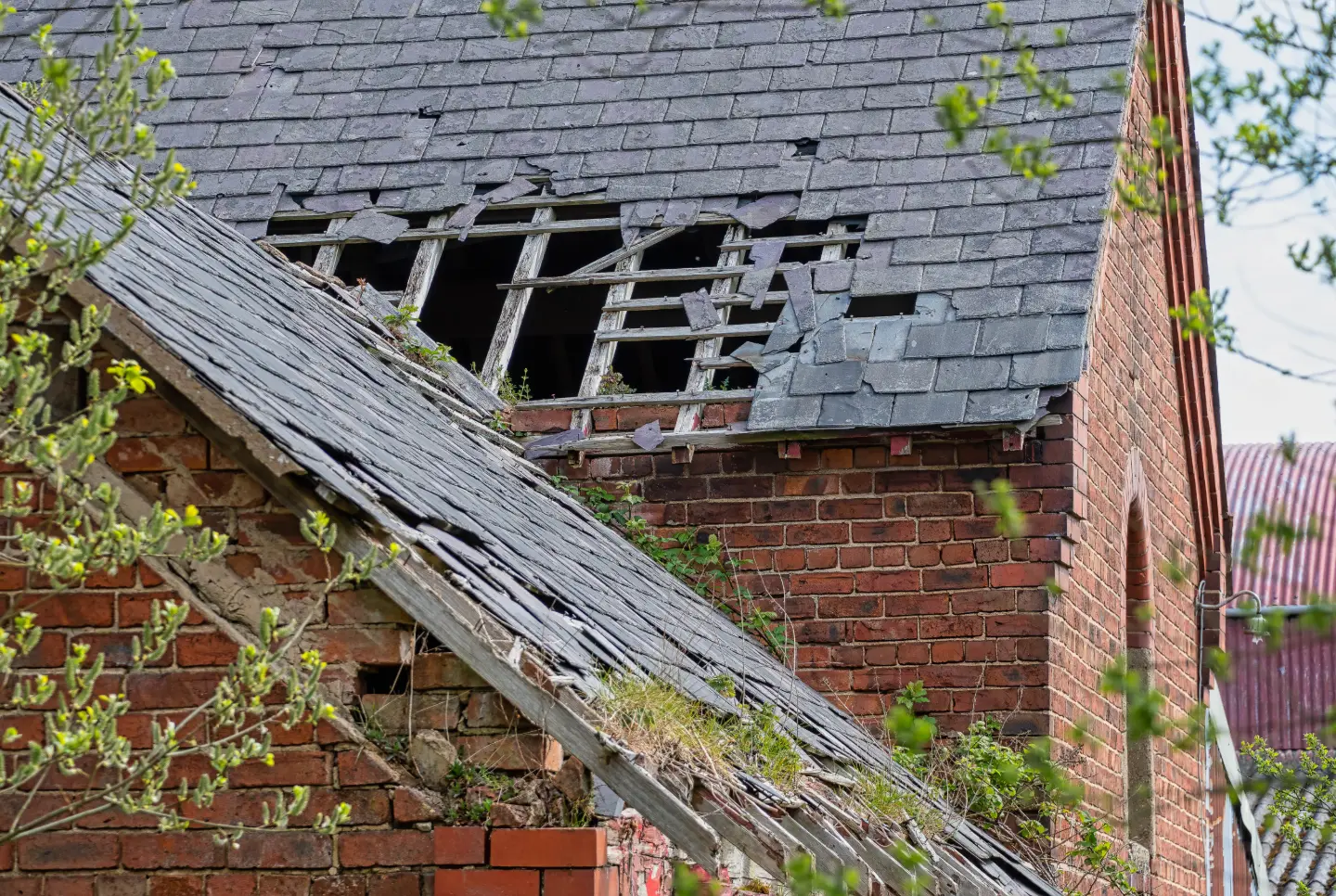 Customer photo of a failing slate roof with missing slates and exposed battens